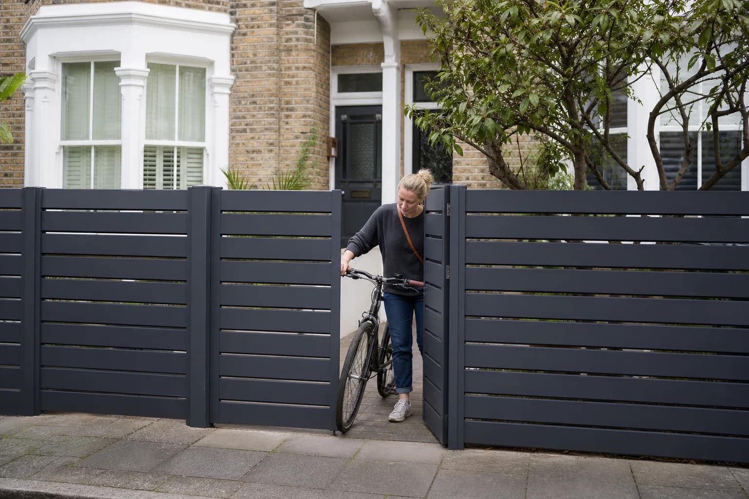 Anthracite-grey aluminium driveway gate at a compact London home