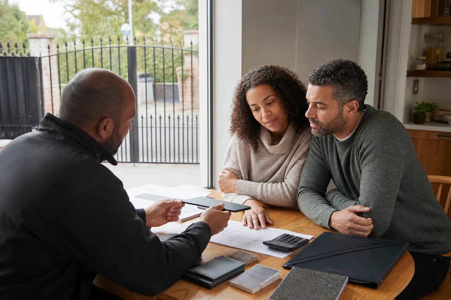 Couple discussing long-term automated-gate costs with an installer
